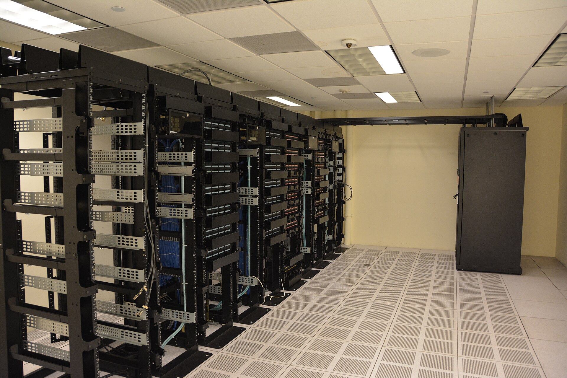 Rows of network racks in a data centre with raised flooring